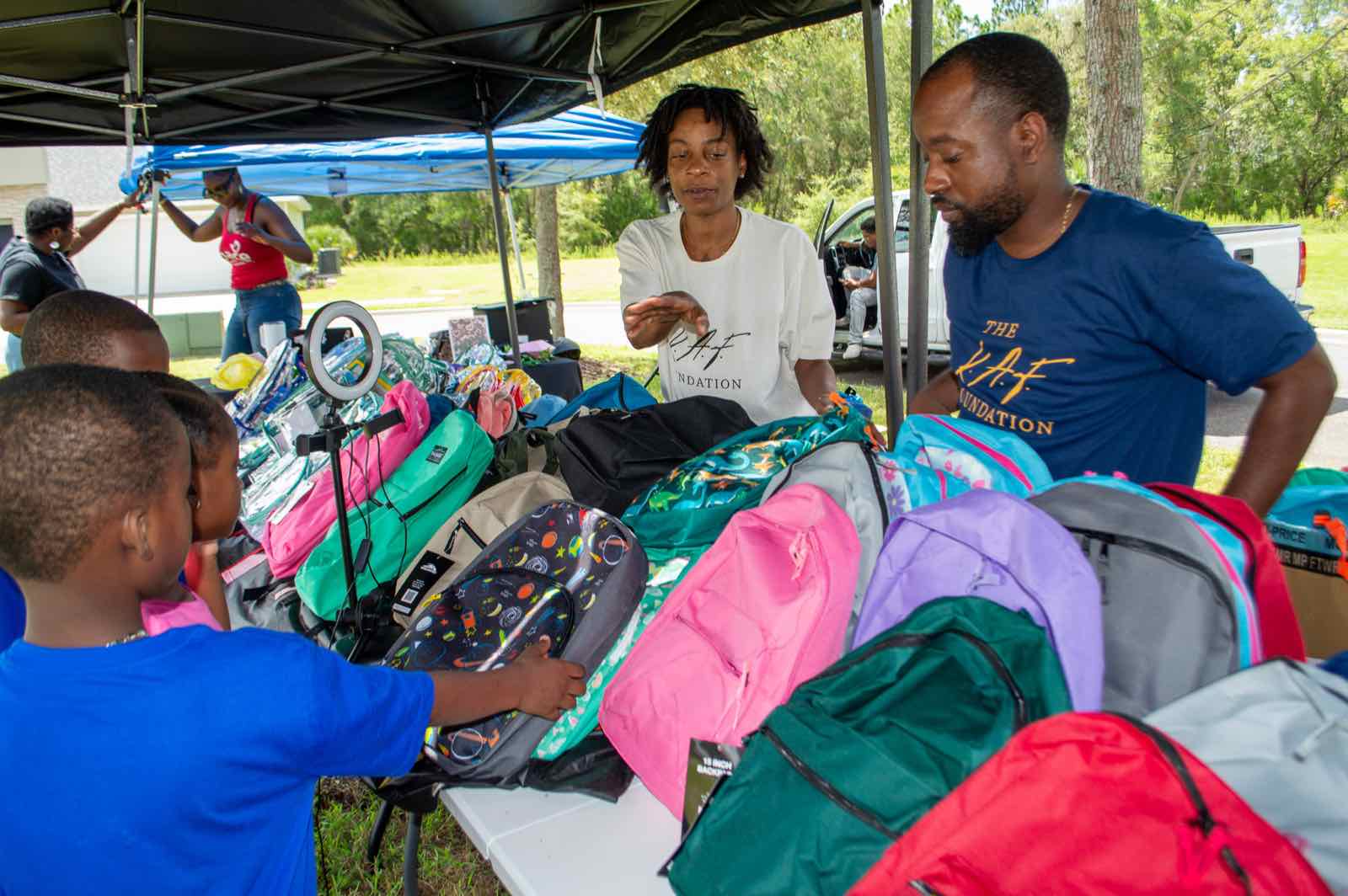 KAF volunteers handing out backpacks to kids at CSRE: BREAKTHROUGH
